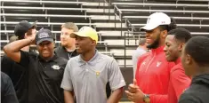  ?? Staff photo by Josh Richert ?? ■ Pleasant Grove football players, from left, Caleb Porchia, Chauncey Martin, Xavier Benson and Cameron Wells take a moment to joke around during a National Signing Day ceremony Wednesday at Pleasant Grove’s Hawk Gym. The four Hawk defenders, along...