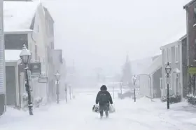  ?? Peter Pereira/Standard Times via AP ?? A woman walks down the street during a snowstorm Monday in New Bedford, Mass.