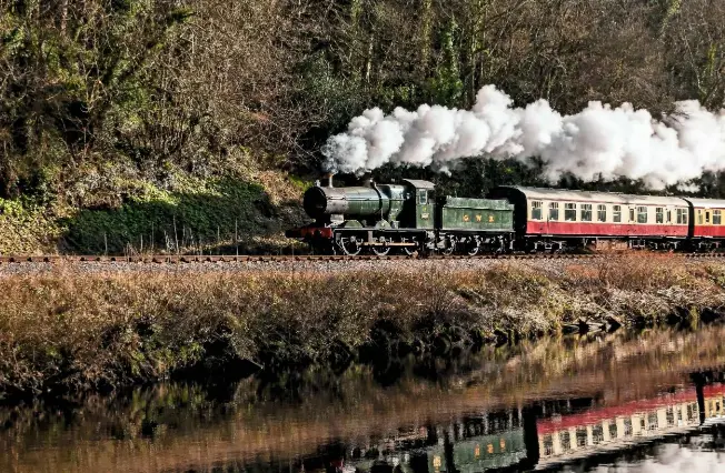  ??  ?? A train steams along the Great Western Railway branch line, hugging the River Dart.