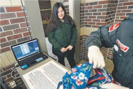  ?? Carlos Osorio, The Associated Press ?? Alondra Alvarez, a student at Western Internatio­nal High School in Detroit, goes through a metal detector and has her bag checked as she heads to class.