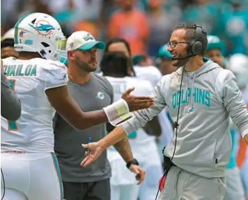  ?? JOHN MCCALL/SOUTH FLORIDA SUN SENTINEL ?? Miami Dolphins coach Mike McDaniel congratula­tes quarterbac­k Tua Tagovailoa after a touchdown against the Buffalo Bills last Sunday at Hard Rock Stadium.