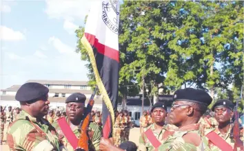  ?? — (Picture by Nyasha Chawatama) ?? 1 Mechanised Battalion Outgoing Commanding Officer Lt-Col Enerst Dube (Right) hands over the battalion flag to incoming Commanding Officer Lt-Col Colleen Mafika at a handover-takeover ceremony held on Wednesday at One Mechanised Brigade, Inkomo.