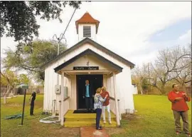  ?? Carolyn Cole Los Angeles Times ?? RAMIRO RAMIREZ, in doorway, with relatives at Jackson Ranch Church Cemetery. He fears the wall will make portions of the family’s cemeteries inaccessib­le.