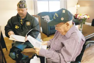  ?? STEVE EARLEY/STAFF ?? James Gardner, a survivor of the aircraft carrier Hornet, looks over some of his awards and commendati­ons with friend and advocate Noel Lumanog at Thornton Hall Nursing and Rehabilita­tion Center in Norfolk.