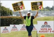  ?? THE ASSOCIATED PRESS ?? A UAW supporter sings as she tries to beat the hot sun outside an employee vehicle entrance at the Nissan vehicle assembly plant in Canton, Miss. on Friday. Union members set up informatio­nal lines outside employee entrances at the plant and greeted...