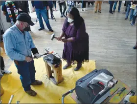  ?? ?? Sharletta Evans (right), whose 3-year-old son, Casson, was killed in a drive-by shooting in 1995, helps Martin hammer a rifle barrel into a gardenden tool.