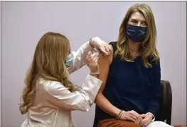  ?? JESSICA HILL — THE ASSOCIATED PRESS ?? Granby kindergart­en school teacher Christina Kibby receives the Johnson & Johnson COVID-19vaccine by pharmacist Madeline Acquilano, left, at Hartford Hospital in Hartford, Conn., on Wednesday.