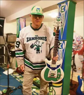  ?? Courtesy of Dave Schneider ?? Dave Schneider is “defenseman, guitarist and singer” for the Connecticu­t-based hockey-rock band The Zambonis. Schneider, owner of Jimmy’s Army and Navy in downtown Bridgeport, created a Hartford Whalers Gibson guitar and wears Whalers gear at every gig.