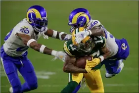  ?? AP PHOTO/MATT LUDTKE ?? Los Angeles Rams’ Samson Ebukam (50) and Rams’ Jalen Ramsey stop Green Bay Packers’ Davante Adams during an NFL divisional playoff football game Saturday, in Green Bay, Wis.