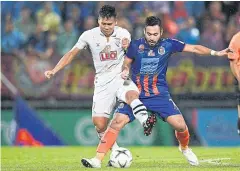  ??  ?? Chiang Rai’s Pitiwat Sukjitthum­makul, left, vies with Port’s Pakorn Prempak during a recent T1 match at PAT Stadium.