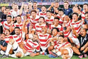  ?? ODD ANDERSEN/AFP ?? Japan’s players pose for a group photo after winning the Rugby World Cup Pool A match against Scotland in Yokohama on Sunday.