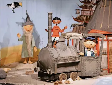  ?? FOTO: DPA ?? Jim Knopf und Lukas mit der Lokomotive Emma gehören zu den bekanntest­en Figuren der Augsburger Puppenkist­e. Und im Hintergrun­d grüßt Tur Tur, der Scheinries­e.