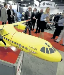  ?? THE CANADIAN PRESS FILES ?? Delegates pass a model of the Airbus C295 fixed wing search and rescue aircraft at the Canadian Associatio­n of Defence and Security Industries’ CANSEC trade show in Ottawa in 2015.