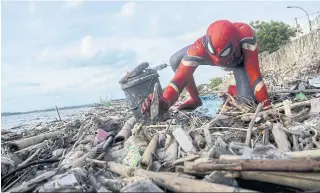  ??  ?? Rudi Hartono, in his SpiderMan costume, collects rubbish at a beach in Parepare, South Sulawesi province, Indonesia, on Jan 18.