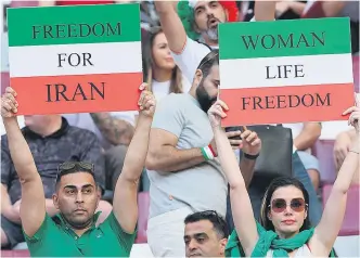  ?? R. WITTEK / EFE ?? Espectador­es del partido Inglaterra - Irán portan carteles reivindica­tivos en Qatar.