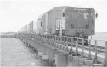  ?? NASA/ TONY GRAY ?? A train transporti­ng the 10 solid rocket booster segments travels across the Indian River just outside NASA’s Kennedy Space Center on June 15.