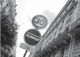  ?? FRANCOIS MORI/AP ?? A speed limit road sign is pictured in a street Monday in Paris as the speed limit on nearly all streets of the French capital was lowered to 30 kph (less than 19 mph).