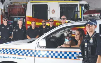  ?? Picture: STEVE HOLLAND ?? Natasha Bull and her dog Turbo who is living out his bucket list with a little help from police officer Senior Sergeant Meg McArthur at Tugun Fire Station. In background (from left) Nathan Jones, Rik Jackson, Mick Grant, Josh Compton, Joe Foster and Noel Bowan.