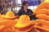  ?? CARRIE ANTLFINGER/ASSOCIATED PRESS ?? Maria Hernandez trims foam cowboy hats at Foamation Inc. in Milwaukee. Foam cheesehead­s have become popular with Packers fans.