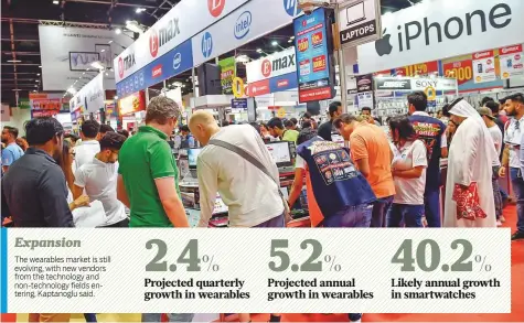  ?? Virendra Saklani/Gulf News ?? Visitors at Gitex Shopper at the Dubai World Trade Centre yesterday. The launch of LTE supported products by Apple will have a positive impact on the consumer market, experts say.
