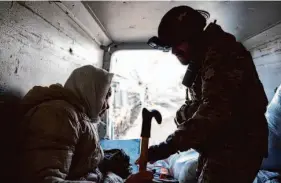  ?? Evgeniy Maloletka/Associated Press ?? A Ukrainian police officer helps an elderly woman Saturday as she evacuates to a safer area in Chasiv Yar near Bakhmut, Ukraine.