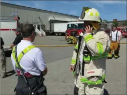 ??  ?? ABOVE: City Fire Chief Paul Shatraw takes a call outside 1 Privilege St. after fire heavily damaged a manufactur­ing plant Monday.