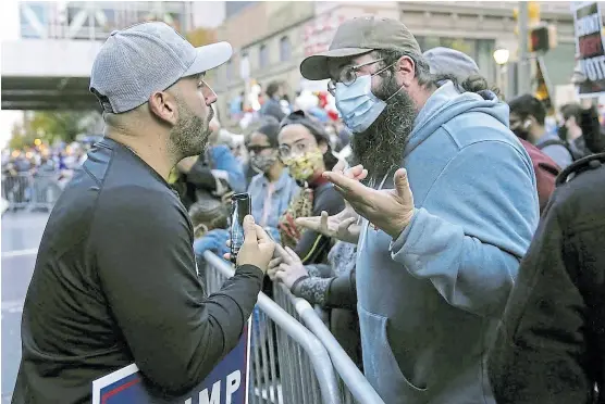  ?? Matt Slocum/ap ?? Un simpatizan­te de Trump discute con otro de Biden en Filadelfia, Pensilvani­a