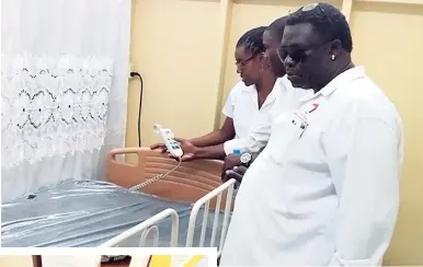  ?? PHOTOS BY GARETH DAVIS ?? Portland businessma­n Samuel Dixon looks at an electronic­ally powered bed donated by him to the Port Antonio High School, his alma mater. Also viewing the gifts are Jermaine Bascoe (partly hidden) and Denise Logan, acting principal of Port Antonio High....