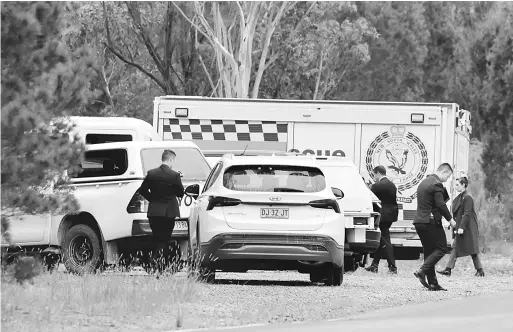  ?? — Gambar AFP ?? PERIKSA: Pasukan polis New South Wales memeriksa lokasi di Bungonia kelmarin di mana mereka menemui mayat seorang pengacara televisyen dan teman lelakinya yang merupakan seorang pramugara.