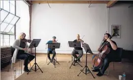  ?? Jenna Schoenefel­d ?? MEMBERS of the rotating Vitamin String Quartet ensemble rehearse in a loft.