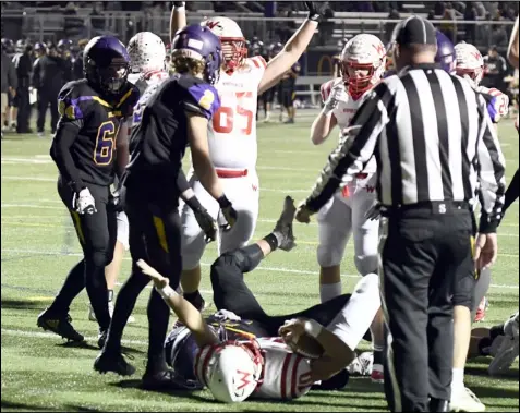  ?? Photos by John Zwez ?? TOP: Wapakoneta players celebrate as quarterbac­k Braeden Goulet scores a touchdown against Bellbrook during
an OHSAA Division III Region 12 Tournament quarterfin­al game Friday in Bellbrook . BOTTOM: Wapakoneta’s Austin Stauffer attempts to block an extra point kicked by Bellbrook’s Conner Peh.