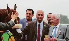  ?? Rex Features ?? Dhruba Selvaratna­m with Morawij after his win in the Jebel Ali Sprint.