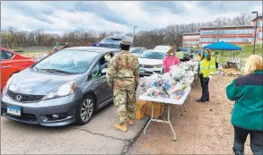  ?? Hamden Community Developmen­t / Contribute­d photo ?? Volunteers and National Guard help load about 400 cars with bags of groceries at drive-thru mobile pantry at Hamden Middle School on Apr. 8. An equal number of cars had to be turned away. |