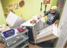  ?? Steve Gonzales / Houston Chronicle ?? Joe Lopez works to clear the kitchen of the Creative Learning Center after floodwater­s hit the day care center in Friendswoo­d.