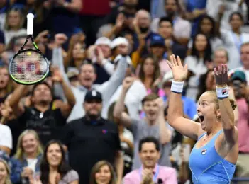  ?? Ed Jones, AFP via Getty Images ?? Shelby Rogers throws her racquet as she celebrates her upset over Australia’s Ashleigh Barty at the U.S. Open on Saturday night.