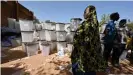  ??  ?? A woman walks past ballot boxes in Burkina Faso