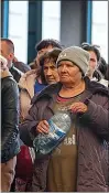  ?? ?? EXODUS: People fleeing the Russian military in eastern Ukraine arrive at Lviv’s central rail station on the train from Dnipro yesterday. Above, right, others wait to board a bus that will take them to Poland