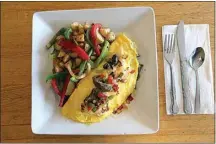  ??  ?? Don’t worry about getting your daily allotment of vegetables with the steak fajita omelet at Maggie’s Sunrise Cafe. Along with Swiss cheese, the dish has plenty of bell peppers and onions, which are also mixed in with the potatoes served on the side.