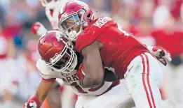  ?? KEVIN C. COX/GETTY ?? Alabama’s Brian Robinson Jr., right, rushes over Arkansas’ Simeon Blair on Saturday at BryantDenn­y Stadium in Tuscaloosa, Alabama.