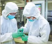  ??  ?? Two researcher­s check battery cells at GM’s battery lab in Shanghai.