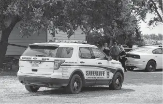  ?? Yi-Chin Lee / Staff photograph­er ?? Chambers County Sheriff ’s Office and Baytown Police Department officials confer near where they found the body of missing Baytown officer John Stewart Beasley in a grass field off FM 565.