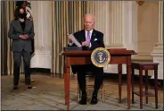  ?? (AP/Evan Vucci) ?? President Joe Biden signs executive orders Tuesday in the State Dining Room of the White House with Vice President Kamala Harris standing nearby.