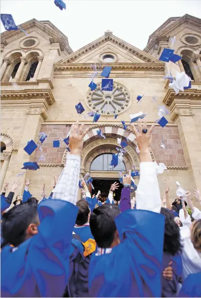  ?? LUIS SÁNCHEZ SATURNO/THE NEW MEXICAN ?? Graduates throw their caps in the air at the St. Michael’s High School graduation last month at the Cathedral Basilica of St. Francis of Assisi.