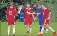  ??  ?? Daniel Croarkin and Donald Campbell congratula­te James Ford on his goal.