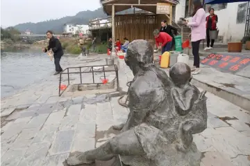  ??  ?? Villagers fill containers with water from a hot spring attraction in Rucheng county, Hunan province, China. Local residents washing vegetables and boiling eggs in the hot springs said the tourism spot, which had cost about 400 million yuan to build, had done little to improve their livelihood­s. – Reuters photo