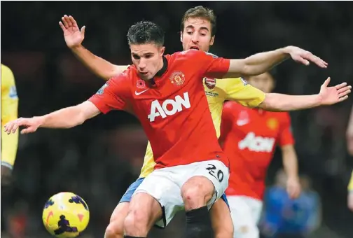  ?? PHIL NOBLE / REUTERS ?? Arsenal’s Mathieu Flamini challenges Manchester United’s Robin van Persie during their English Premier League match at Old Trafford in Manchester, northern England on Sunday. Van Persie scored the game’s only goal after attacking a Wayne Rooney corner...