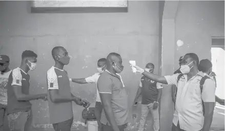  ?? DIEU NALIO CHERY/AP ?? Health ministry workers check the temperatur­e of fans entering a stadium before a soccer match March 25 in Port-au-Prince, Haiti.