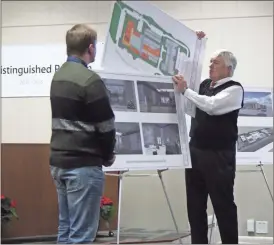  ??  ?? Superinten­dent William Hunter (right) did one last bit of heavy lifting during the Board of Education meeting on Dec. 13, showing off plans for a theater at Cedartown High School to be mainly utilized by the drama students, taught by Chris Reeves (left.)
