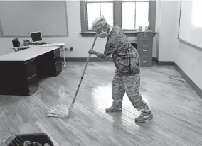  ?? [FRED SQUILLANTE/DISPATCH] ?? Custodian Mitchell Russell mops a classroom floor at Fort Hayes Arts and Academic High School, 546 Jack Gibbs Blvd., on July 9. Plans for a blended opening this fall of Columbus City Schools buildings for students in grades K-8 may be put on hold amid rising coronaviru­s cases.