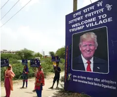  ?? AFP photo ?? Indian children hold placards by the entrance gate of Marora village, which has been unofficial­ly renamed ‘Trump Village,’ about 100km from New Delhi. —